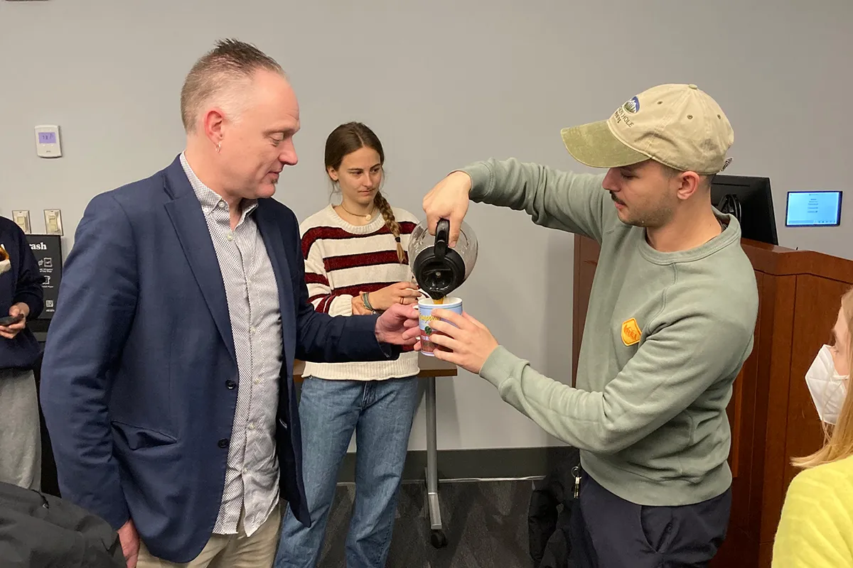 Geoffrey pouring coffee for Dr. Mat Coleman at a "Geography of Coffee" event put together by the Geography club
