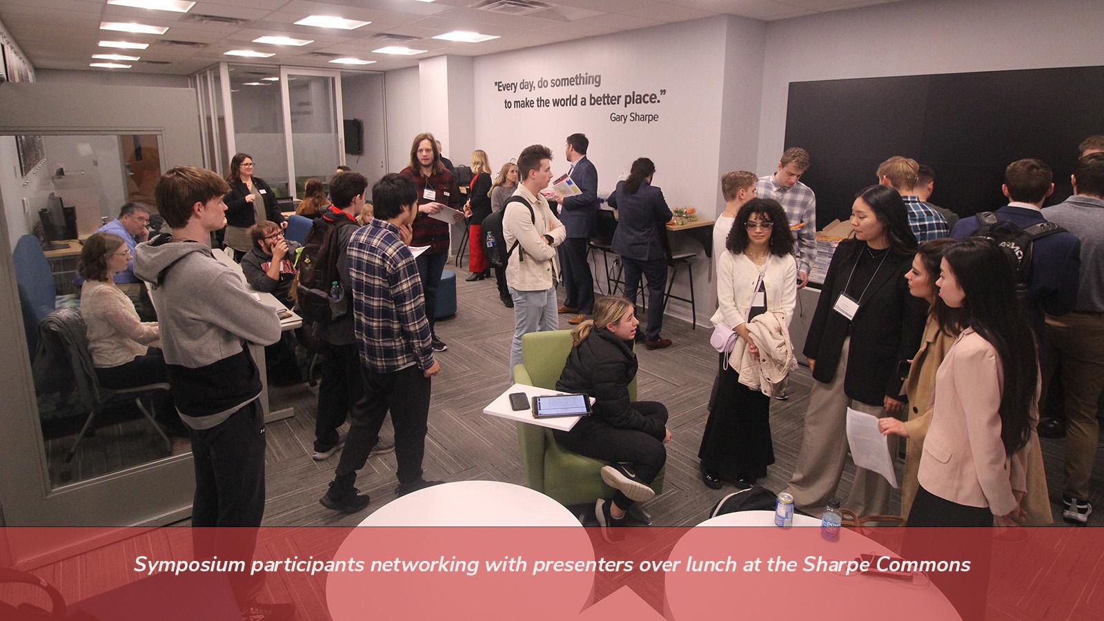 Symposium participants networking with presenters over lunch at the Sharpe Commons