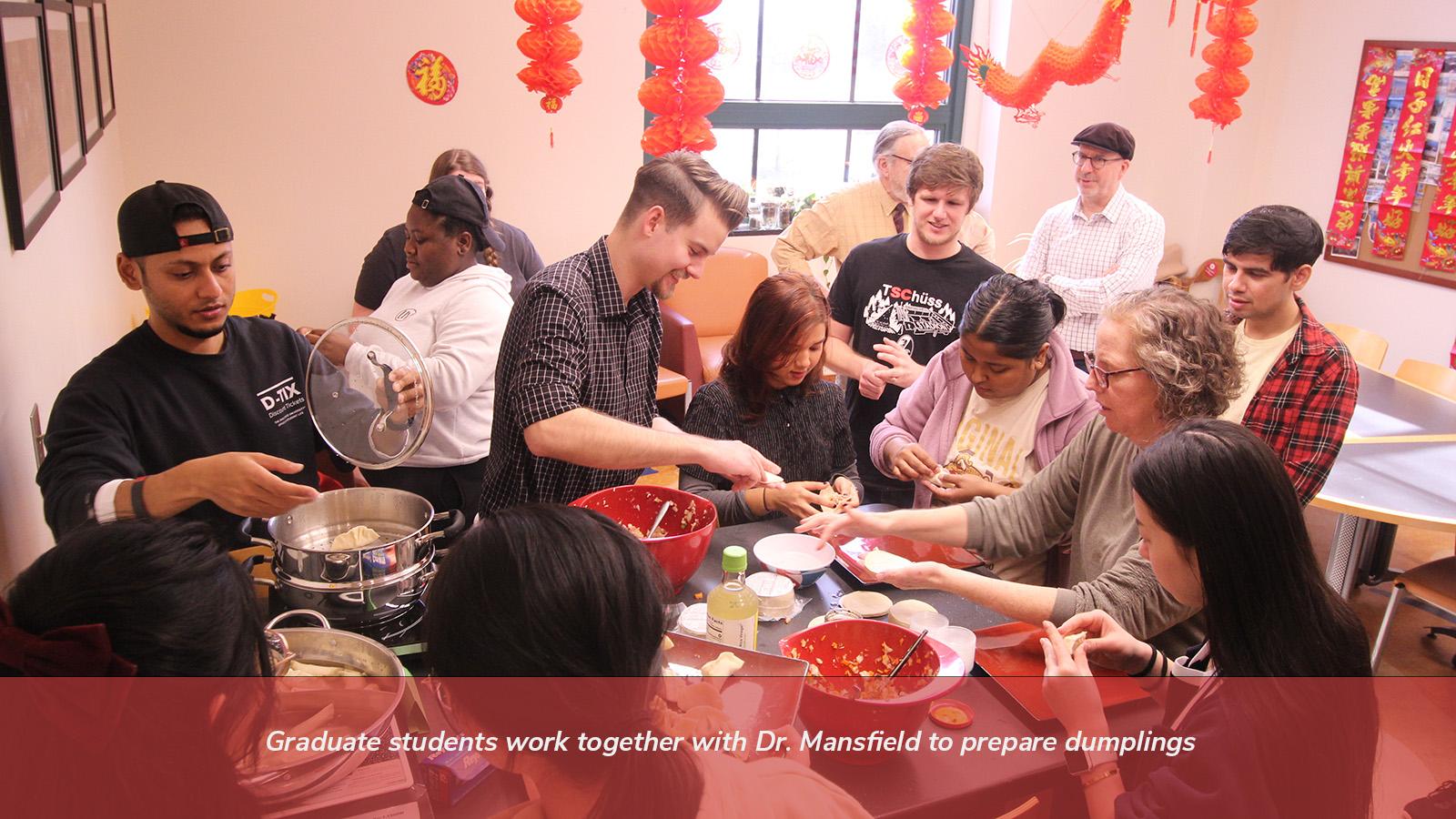 Graduate students work together with Dr. Mansfield to prepare dumplings