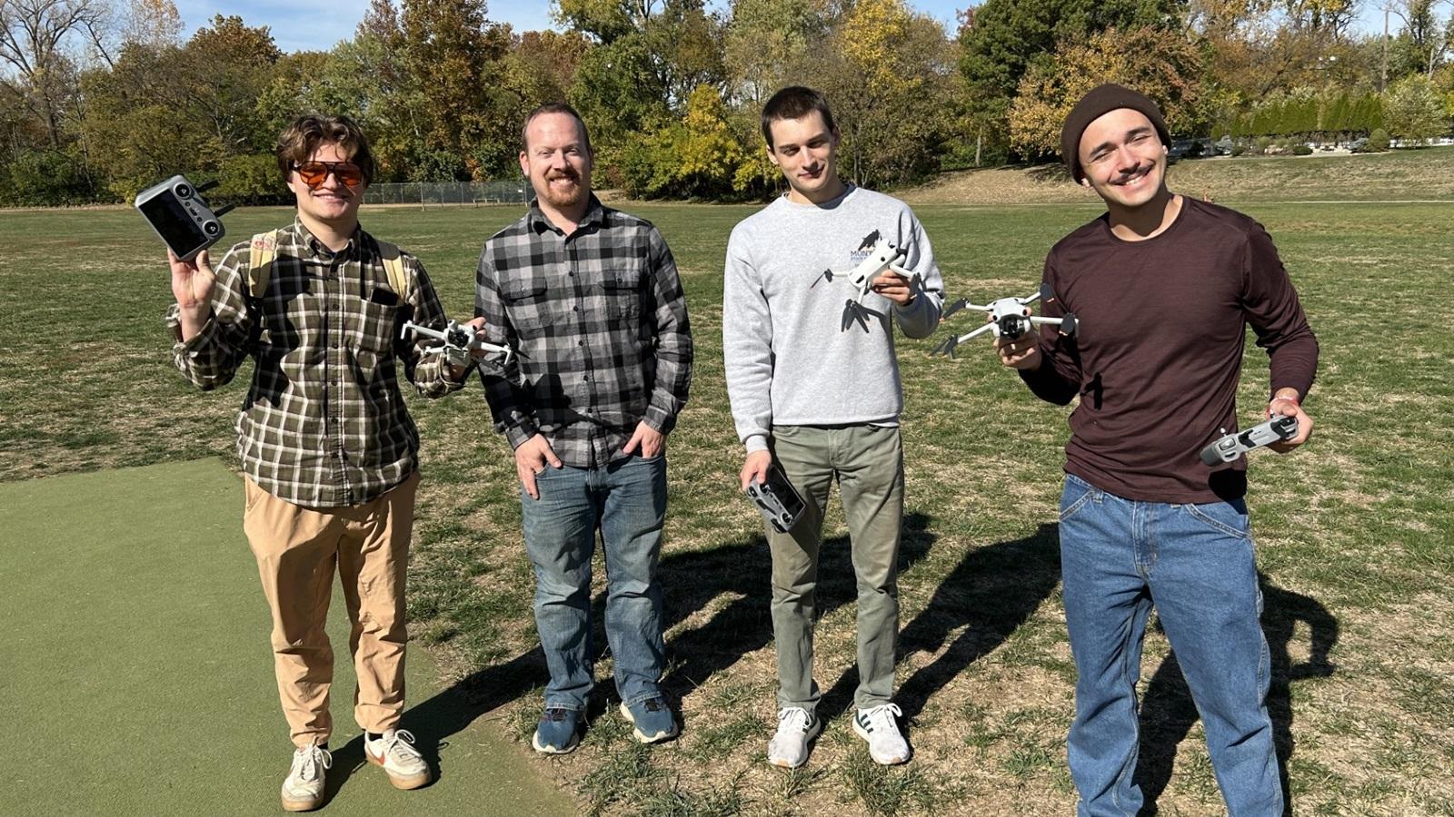 Harrison, Jon, Eric and Geoff stand in the park showing off the SFL drones
