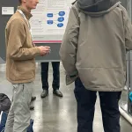 Ethan Hersey discussing poster with AMS Attendee