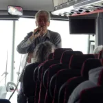 Ken Apacki talking to students on bus