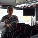 Ken Apacki talking to students on bus