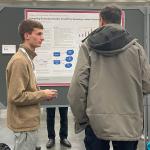 Ethan Hersey discussing poster with AMS Attendee