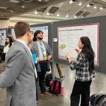 Logan Wallen and Yu Liu discuss their poster with AMS Attendee