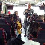Ken Apacki talking to students on bus