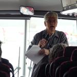 Ken Apacki talking to students on bus
